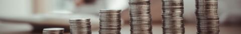 Stacks of coins arranged in ascending order on a table.