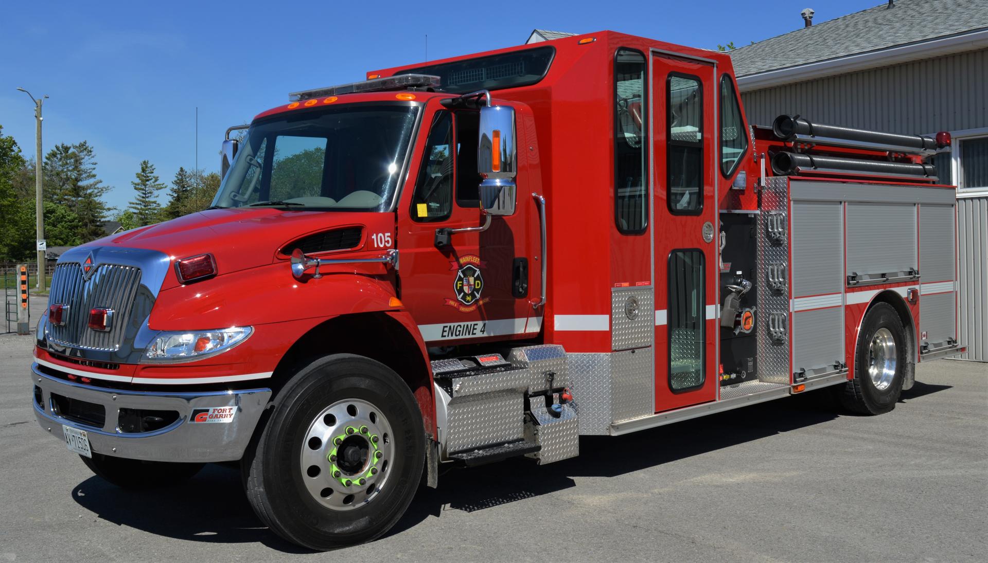 Red fire engine marked 105 with Wainfleet Fire Department logo, parked outside.
